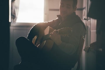 Backlight of man playing Spanish guitar.