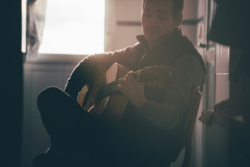 Backlight of man playing Spanish guitar.