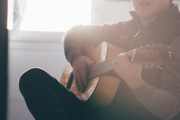 Backlight of man playing Spanish guitar.