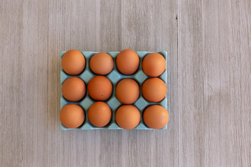 Organic Brown Chicken eggs in a Blue Plastic Box on a Wooden Table . Top view. Easter Concept.