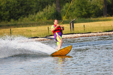 Älterer Mann mit Übergewicht beim Wakeboarden