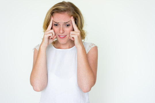 Stressed young woman touching temples. Lady having headache. Stress or headache concept. Isolated front view on white background.