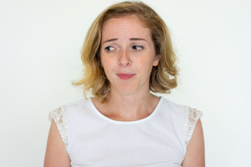 Worried young woman thinking. Pretty lady looking away. Contemplation concept. Isolated front view on white background.