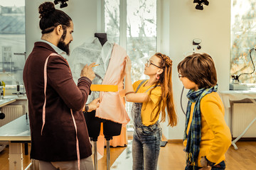 Red-haired girl wearing denim jumpsuit helping father