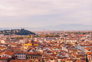 Fototapeta na wymiar Beautifu view of city skyline, towers, basilicas, red-tiled roofs of houses and mountains, Florence, Italy
