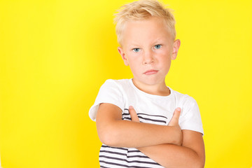 Cute blond boy portrait on yellow background