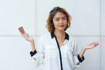 Confident Asian girl advertising credit card. Beautiful young woman spreading hands and holding blank plastic card. Payment concept