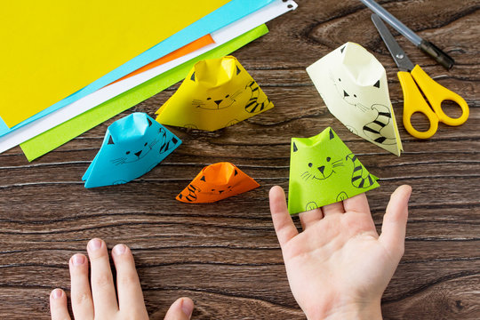 Origami toy made from paper puppets cat. Glue, scissors and paper on a wooden table. Children's art project craft for kids. Craft for children.