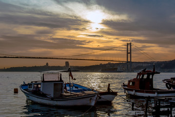 Fototapeta na wymiar Istanbul, Turkey, 22 March 2006: Sunset, Boats and Bosphorus Bridge, Cengelkoy