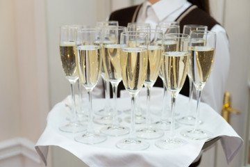 Champagne glasses on tray in bright lights. Party or celebration