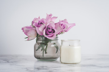 pink roses and a candle on a marble kitchen counter