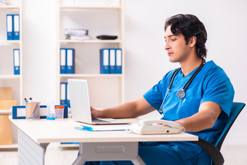 Young handsome doctor working at the clinic 