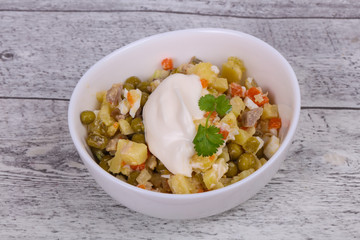 Traditional Russian salad with chicken in the white bowl