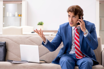 Young businessman working at home sitting on the sofa 