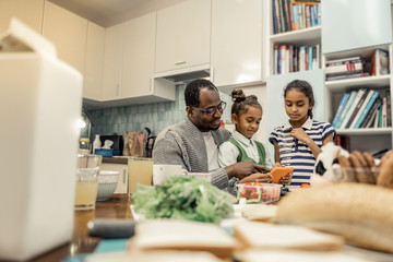 Fototapeta premium Two cute stylish daughters spending morning with their loving father