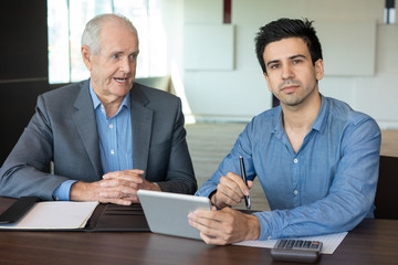 Junior officer making notes on senior executive comments. Young employee listening to boss giving advice about changing business strategy. Business project review concept