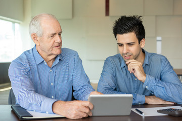 Senior colleague describing task to young employee. Staff member carefully listening to boss...