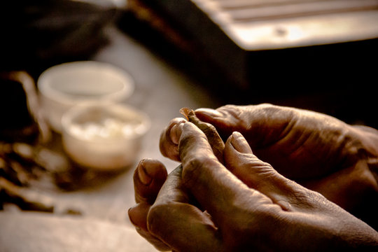 Masterful hands rolling a handmade Habano cigar in Havana, Cuba &mdash; a close-up tribute to artisanal craftsmanship and the heritage of fine tobacco.