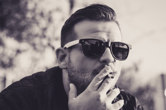 M&auml;nnerportrait mit Sonnenbrille und Zigarette (Schwarz Wei&szlig;)