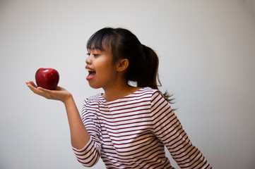 20s teenager Filipino woman with red apple portrait on casual cloth background