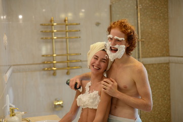 loving couple in the bathroom shaving foam