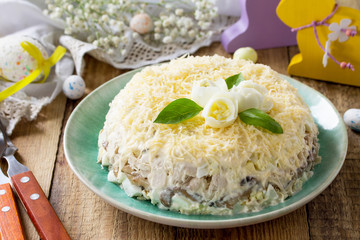 Festive snack on Easter table. Salad with eggs, chicken, mushrooms and cheese.