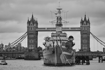 Desaturized or black and white picture of british light cruiser ship HMS Belfast in front of Tower...