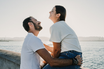 .Young and beautiful couple in love enjoying an afternoon outdoors in Gijón, in Asturias (Spain) overlooking the sea. A fun and playful couple. Love. Lifestyle.
