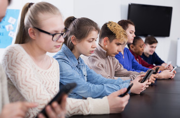 Male and female students playing with smartphones