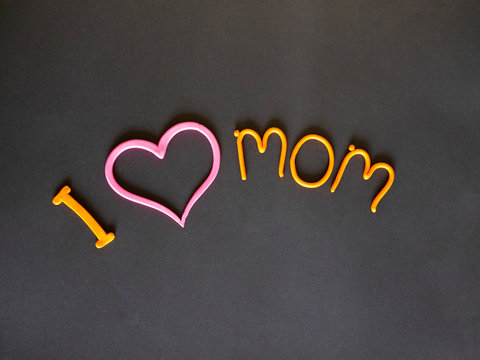 I love my mother the inscription of yellow plasticine with a pink heart