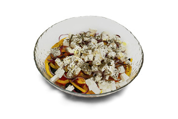 big glass plate of fresh Greek salad isolated on a white background