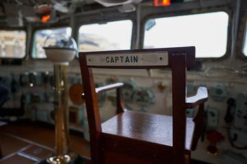 Captain's chair in bridge of british light cruiser HMS Belfast who served in Royal British navy during and after WWII and now is exhibited like museum ship in London. 