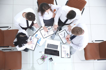 top view. business team standing near the desktop.the concept of teamwork