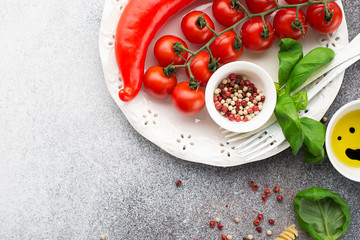 Ingredients for cooking. Cherry tomatoes, paprika, basil, pink pepper, sea salt, pasta on a light background. Top view. Copy space