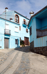 Street in a village of white houses in the Spanish province of Malaga called Casares on a sunny day.
