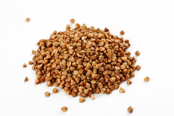 Pile of raw buckwheat seeds on a white background