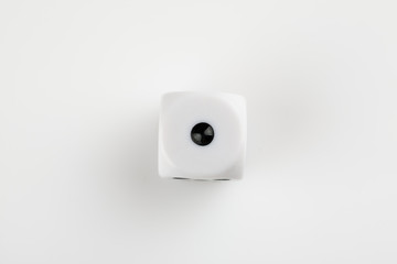 Single white with black dots dice on a white background, showing number one