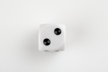 Single white with black dots dice on a white background, showing number two