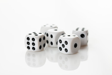 Pile of white with black dots dice on a white background