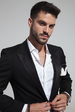portrait of handsome fashion man buttoning black suit