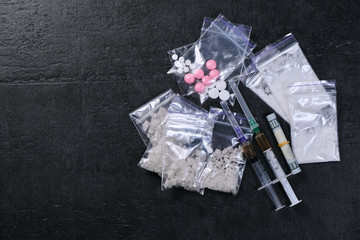 Money and drugs. syringe with heroin. scattered pills. Copyspace.
