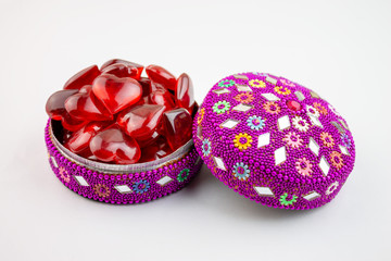 Colorful jewelry box full of red hearts on white bacground - valentine day concept