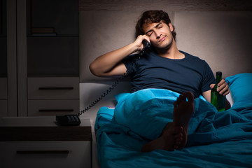 Fototapeta premium Man drinking in the bed under stress