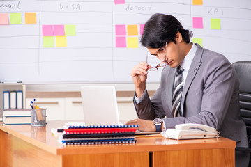 Young handsome employee working in the office