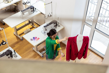 Brunette asian designer with bright makeup looking focused