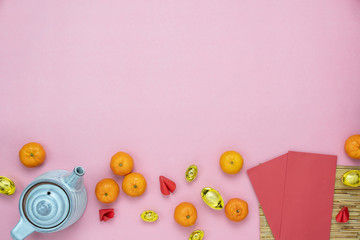 Chinese language mean rich or wealthy and happy.Table top view Lunar New Year & Chinese New Year concept background.Flat lay object the tea cup orange & red pocket money with gold decor on pink paper.