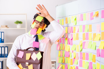 Young employee in conflicting priorities concept 