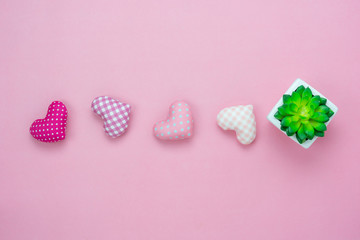 Table top view aerial image of decoration valentine's day or earth day background concept.Flat lay essential items tree pot and colorful love shape on modern pink paper.blank space for mock up.
