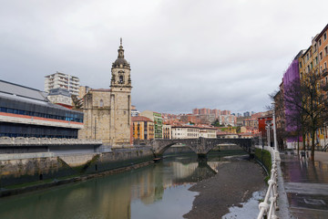 Fototapeta na wymiar San Anton church and the Ribera market, in the old town of Bilbao, Basque Country, Spain. On a cloudy day.