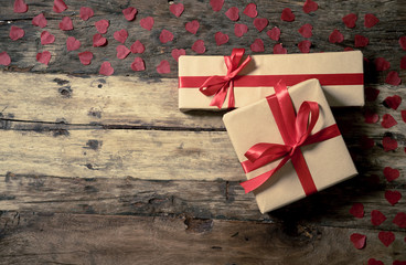 Conceptual image of Happy Saint valentines day wrapped gifts and red hearts on wooden vintage table